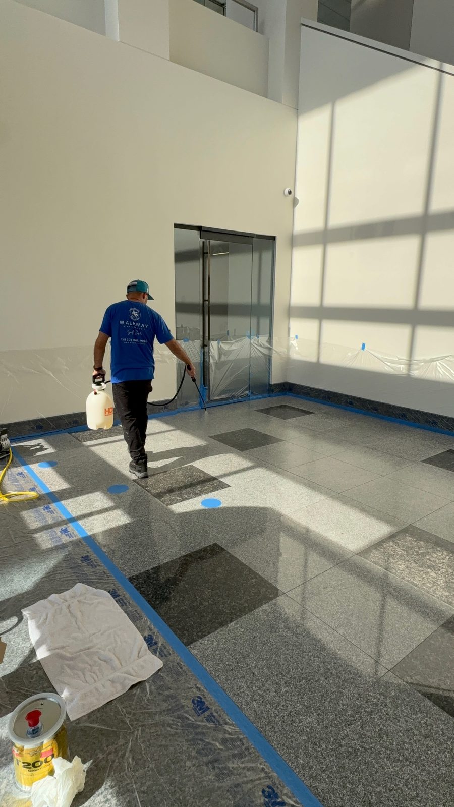 Walkway Management technician applying an anti-slip treatment to a terrazzo floor