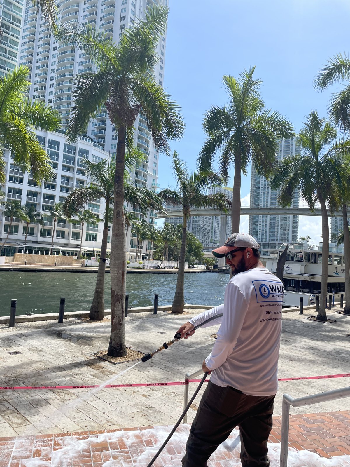 Treating a waterfront deck, skyline behind.